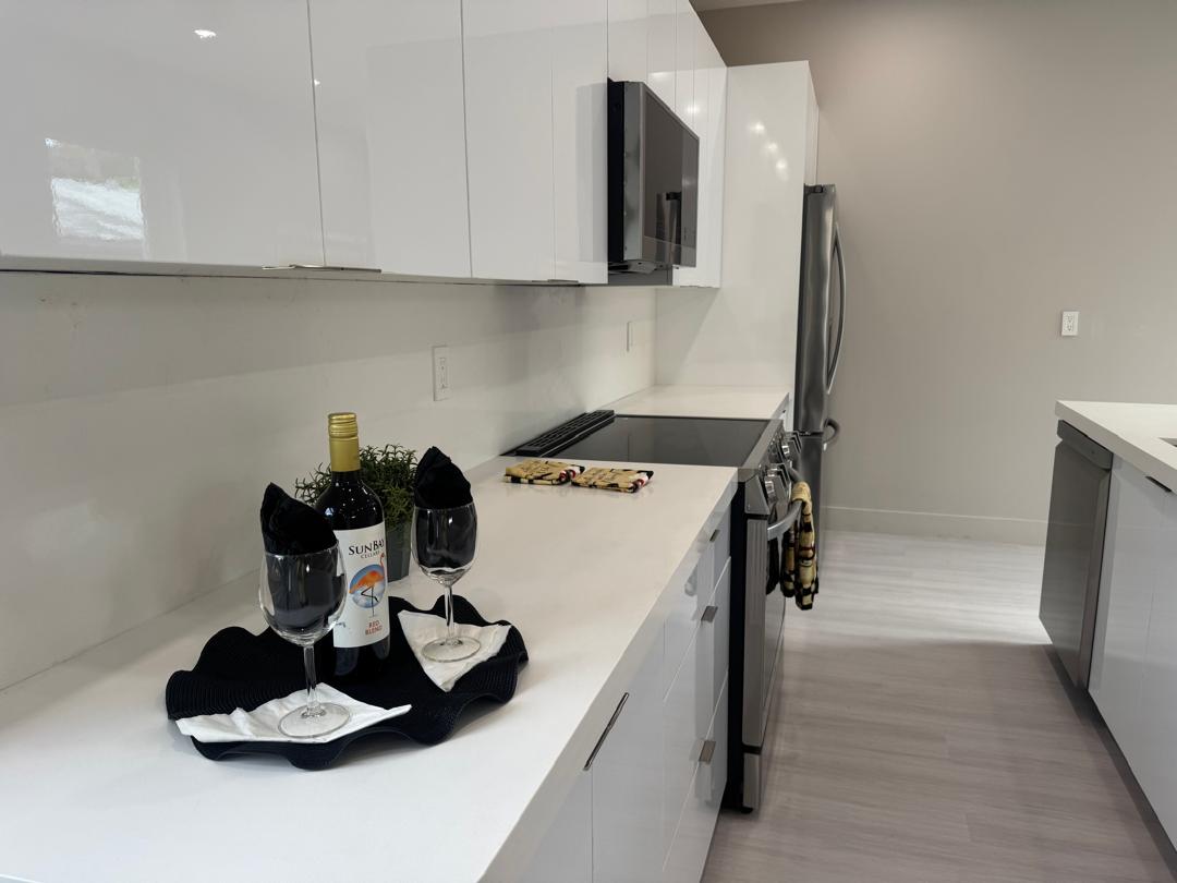 Remodeled kitchen with white countertop styled with wine glasses and bottle
