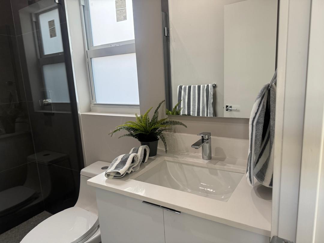 Remodeled bathroom with bright window, white vanity and decorative details